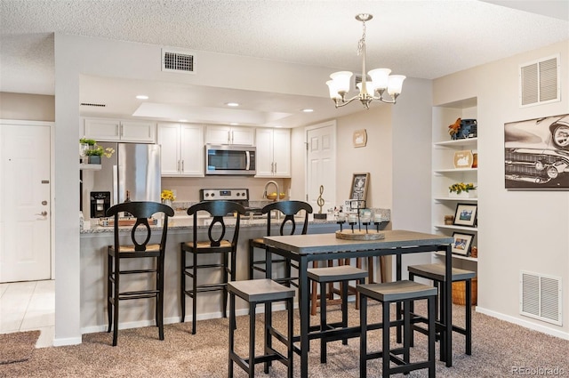 23585 Genesee Village Rd Unit E, Golden, CO 80401 - dining room featuring light colored carpet, a chandelier, a textured ceiling, and recessed lighting