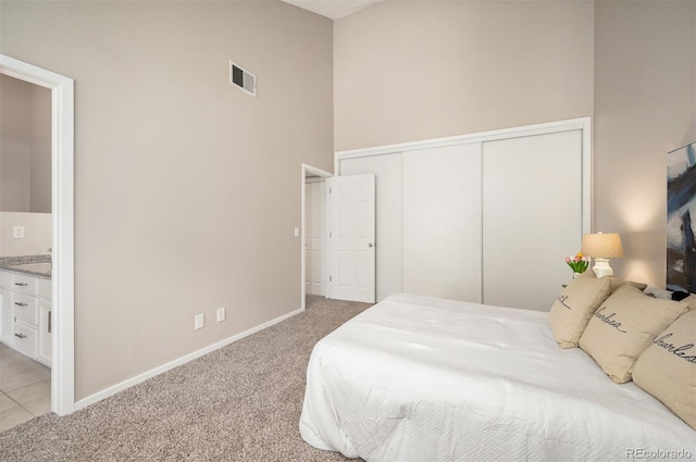 23585 Genesee Village Rd Unit E, Golden, CO 80401 - bedroom with a towering ceiling, light carpet, a closet, and ensuite bathroom