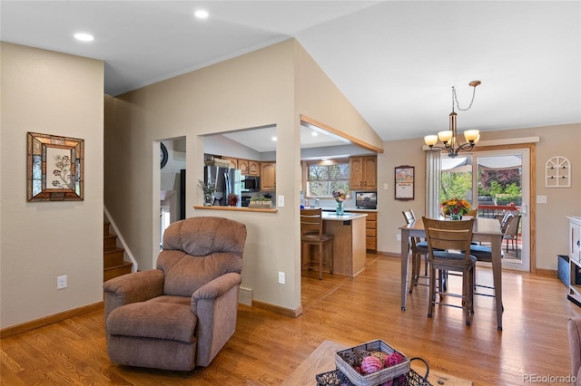 9700 W 88th Pl, Westminster, CO 80021 - dining space featuring a chandelier, stairway, light wood-type flooring, lofted ceiling, and baseboards