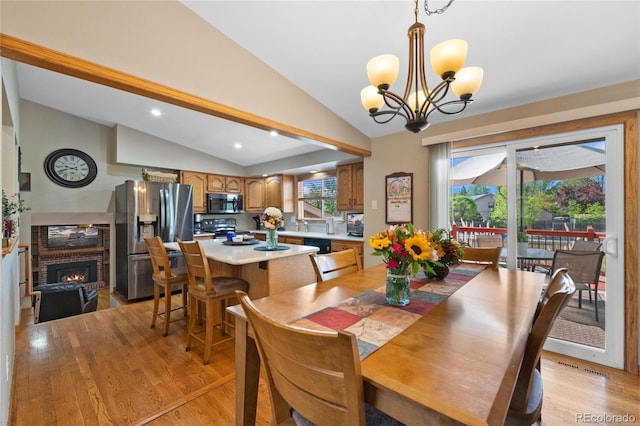 9700 W 88th Pl, Westminster, CO 80021 - dining area featuring lofted ceiling, light wood-type flooring, a chandelier, a brick fireplace, and recessed lighting