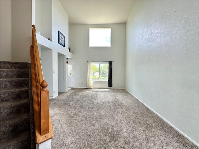 2033 Espana Way, Aurora, CO 80011 - unfurnished living room featuring a towering ceiling, carpet, and baseboards