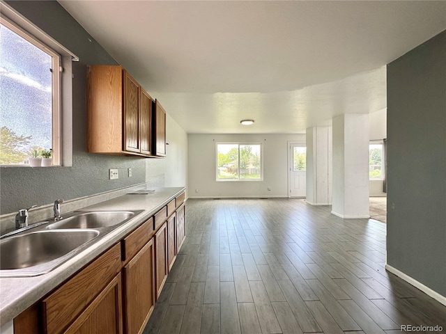 2033 Espana Way, Aurora, CO 80011 - kitchen with open floor plan, a sink, brown cabinetry, and baseboards