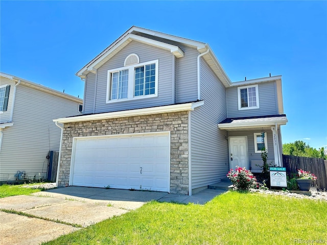2033 Espana Way, Aurora, CO 80011 - traditional home with an attached garage, stone siding, and concrete driveway