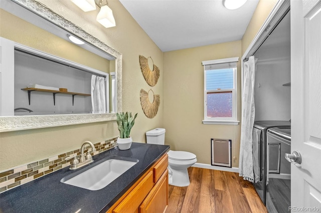 14712 Josephine St, Thornton, CO 80602 - full bathroom featuring independent washer and dryer, wood finished floors, vanity, and backsplash