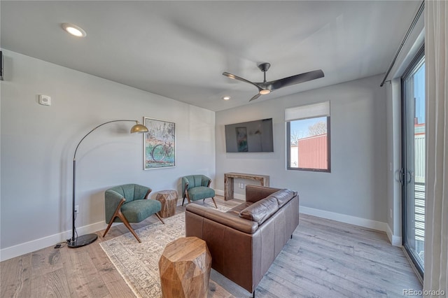 living area with a ceiling fan, recessed lighting, light wood-style flooring, and baseboards