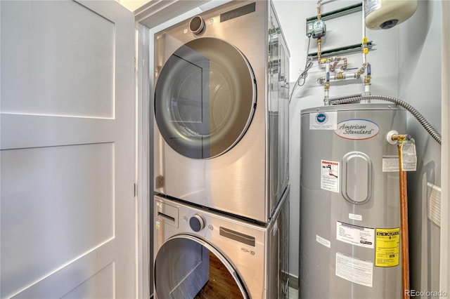 clothes washing area featuring stacked washer and dryer, laundry area, and electric water heater