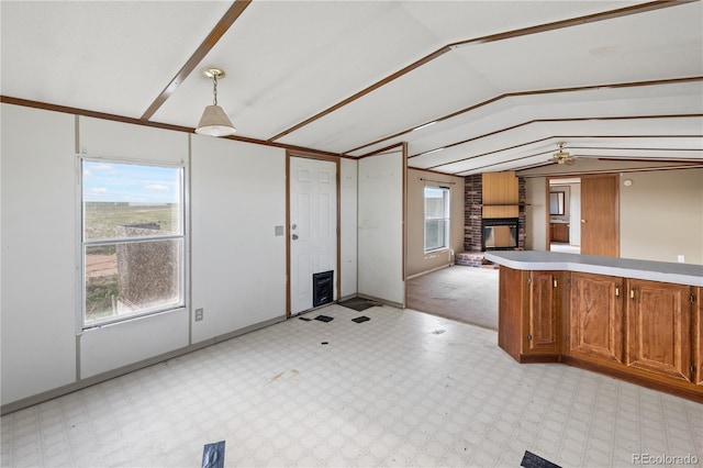 35275 Book Rd, Yoder, CO 80864 - kitchen featuring lofted ceiling, a fireplace, light floors, brown cabinets, and light countertops