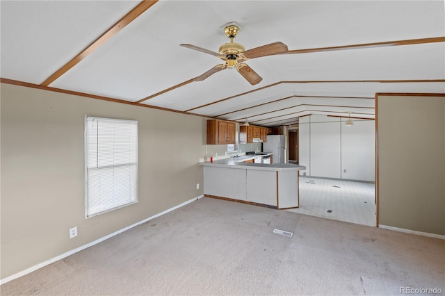35275 Book Rd, Yoder, CO 80864 - kitchen featuring a peninsula, lofted ceiling, freestanding refrigerator, a ceiling fan, and light colored carpet