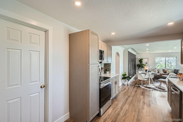 5555 Julian St, Denver, CO 80221 - kitchen with stainless steel appliances, arched walkways, open floor plan, baseboards, and recessed lighting