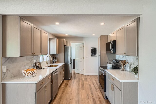 5555 Julian St, Denver, CO 80221 - kitchen featuring stainless steel appliances, a sink, tasteful backsplash, light wood-style flooring, and light countertops