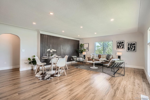 5555 Julian St, Denver, CO 80221 - living room featuring arched walkways, wood finished floors, recessed lighting, baseboards, and a textured ceiling