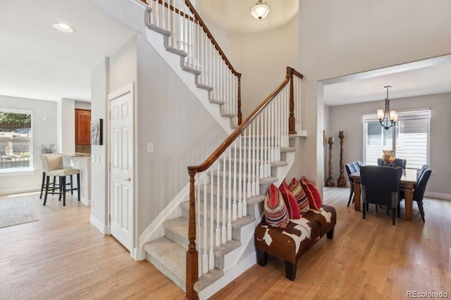 3102 Fox Sedge Pl, Highlands Ranch, CO 80126 - stairway featuring wood finished floors, healthy amount of natural light, and a chandelier