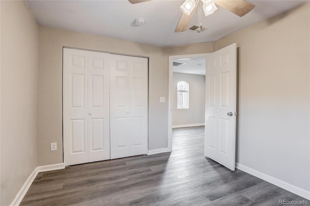 unfurnished bedroom with baseboards, a closet, and wood finished floors