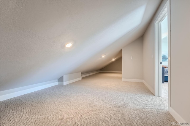 15290 W 69th Pl, Arvada, CO 80007 - additional living space with light colored carpet, vaulted ceiling, and a textured ceiling