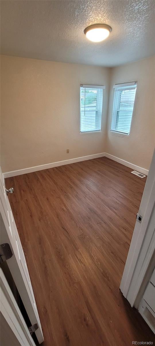 2880 W 91st Pl, Denver, CO 80260 - empty room featuring a textured ceiling, wood finished floors, and baseboards