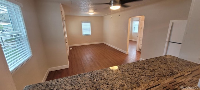 2880 W 91st Pl, Denver, CO 80260 - empty room with arched walkways, wood finished floors, ceiling fan, and baseboards