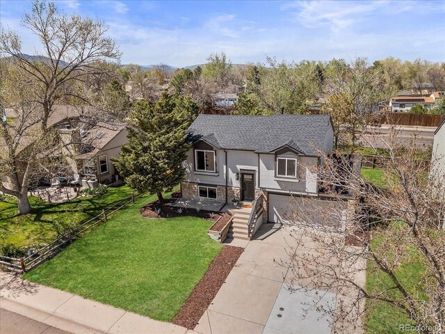 10895 W Bowles Pl, Littleton, CO 80127 - raised ranch with concrete driveway, a shingled roof, an attached garage, and brick siding