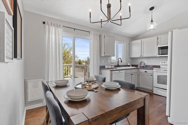 10895 W Bowles Pl, Littleton, CO 80127 - dining space featuring a textured ceiling, a chandelier, dark wood-type flooring, and vaulted ceiling