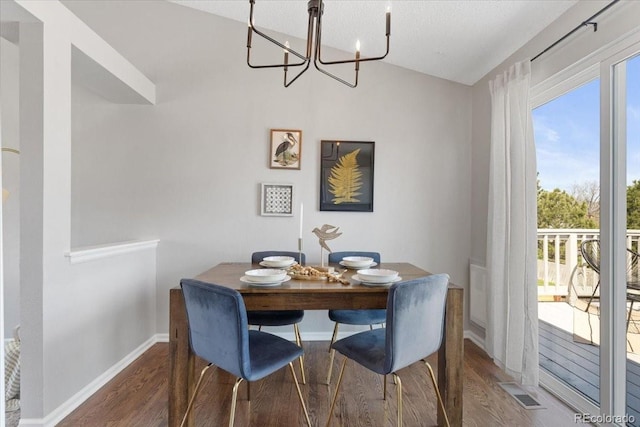 10895 W Bowles Pl, Littleton, CO 80127 - dining room featuring a chandelier, wood finished floors, vaulted ceiling, and baseboards