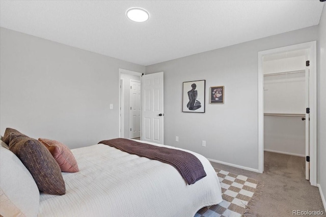 10895 W Bowles Pl, Littleton, CO 80127 - bedroom featuring carpet floors, a walk in closet, baseboards, and a closet