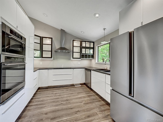 15915 E Mercer Cir, Aurora, CO 80013 - kitchen featuring stainless steel appliances, wall chimney exhaust hood, dark countertops, wood finished floors, and vaulted ceiling