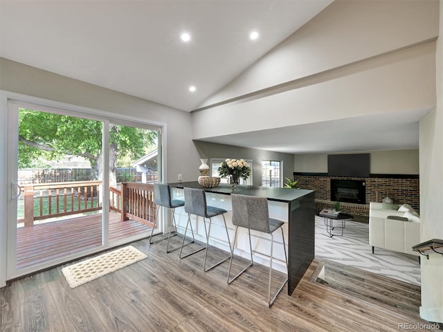 15915 E Mercer Cir, Aurora, CO 80013 - kitchen featuring wood finished floors, dark countertops, recessed lighting, a kitchen breakfast bar, and a peninsula