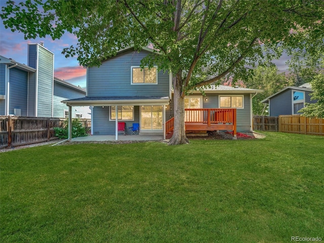 15915 E Mercer Cir, Aurora, CO 80013 - back of property at dusk with a patio area, a fenced backyard, and a wooden deck