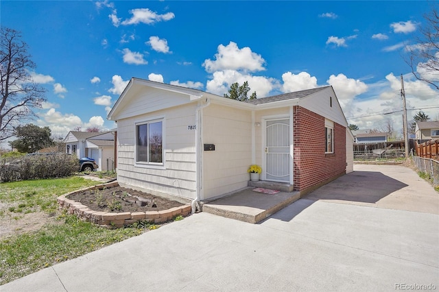 7819 Tejon St, Denver, CO 80221 - view of front of home with a patio area, brick siding, and driveway