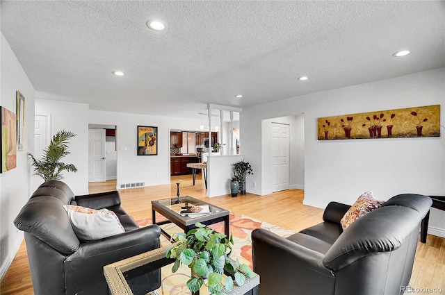 7819 Tejon St, Denver, CO 80221 - living room with light wood-type flooring, recessed lighting, and a textured ceiling
