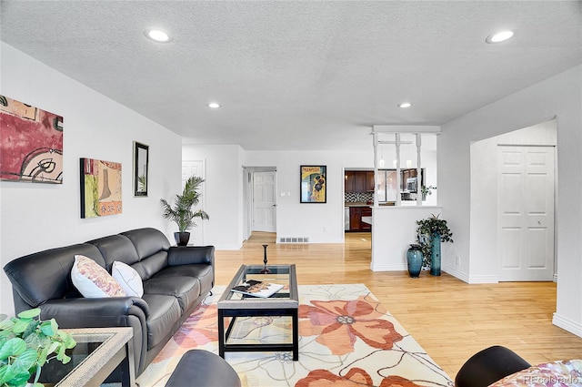 7819 Tejon St, Denver, CO 80221 - living room featuring light wood-style flooring, recessed lighting, and a textured ceiling