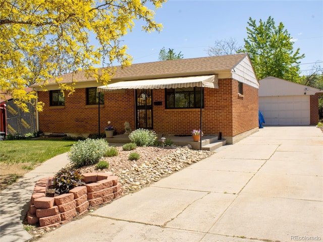 660 Wolff St, Denver, CO 80204 - view of front of property featuring an outdoor structure, a garage, brick siding, and roof with shingles