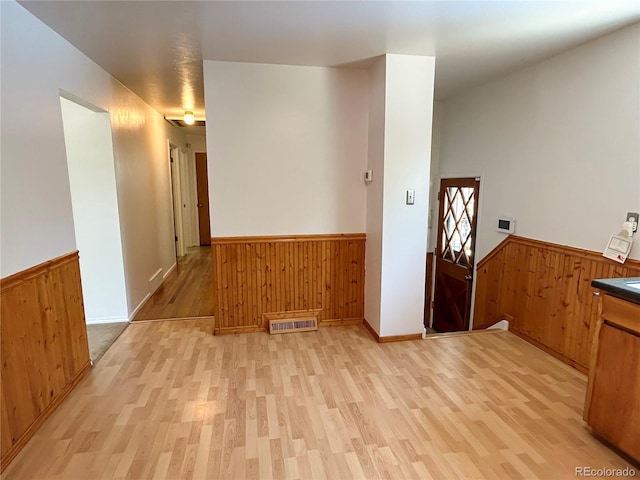 660 Wolff St, Denver, CO 80204 - unfurnished dining area with a wainscoted wall, wooden walls, and light wood-style flooring