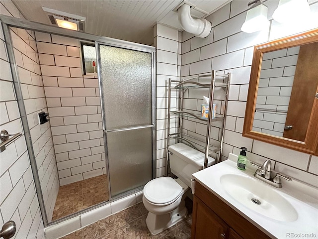 660 Wolff St, Denver, CO 80204 - bathroom featuring tile walls, toilet, vanity, a stall shower, and backsplash