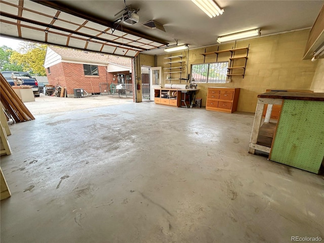 660 Wolff St, Denver, CO 80204 - garage featuring a garage door opener, a workshop area, and concrete block wall