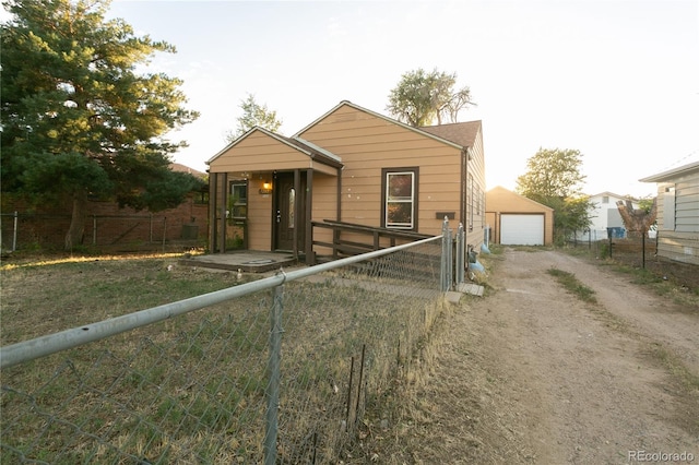 bungalow with a garage and an outbuilding