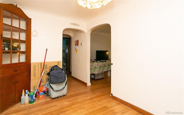 7261 Magnolia St, Commerce City, CO 80022 - corridor with arched walkways, baseboards, and light wood-style floors