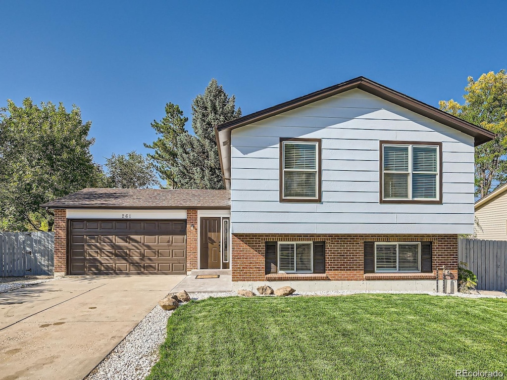 split level home featuring a front yard and a garage