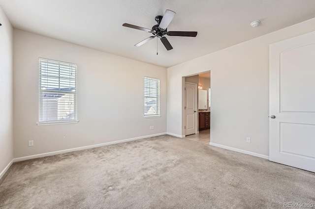 unfurnished bedroom with ensuite bathroom, ceiling fan, and light colored carpet