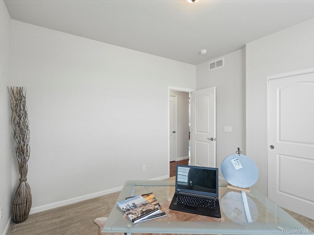 carpeted office featuring visible vents and baseboards