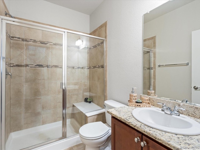 bathroom featuring a shower stall, toilet, a textured wall, and vanity
