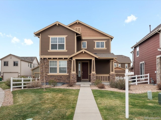craftsman-style home with a garage, stone siding, a front yard, and fence