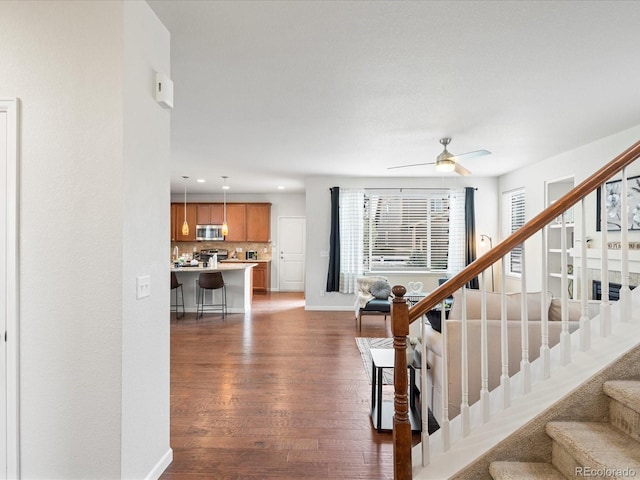 stairs with baseboards, a ceiling fan, wood finished floors, and recessed lighting
