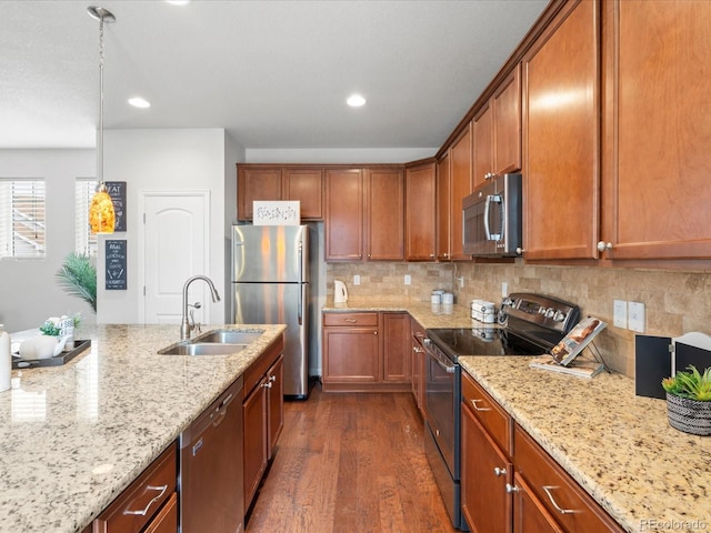 kitchen featuring dark wood finished floors, brown cabinets, appliances with stainless steel finishes, and a sink