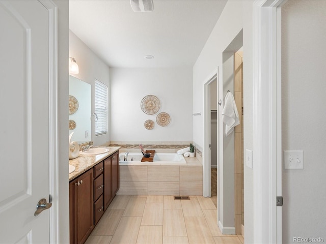 full bathroom with a sink, tile patterned floors, a bath, double vanity, and visible vents