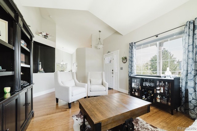15389 E 99th Way, Commerce City, CO 80022 - living area featuring vaulted ceiling, light wood finished floors, a chandelier, and baseboards