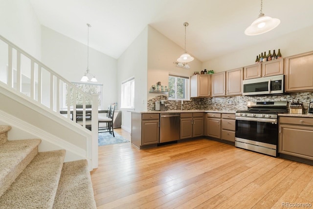 15389 E 99th Way, Commerce City, CO 80022 - kitchen with appliances with stainless steel finishes, high vaulted ceiling, backsplash, a chandelier, and decorative light fixtures