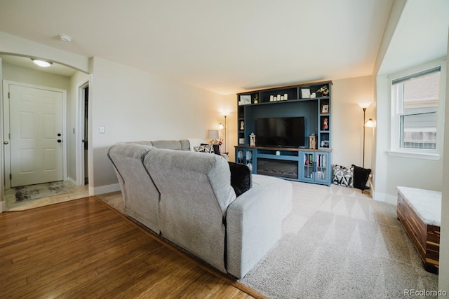 15389 E 99th Way, Commerce City, CO 80022 - living room featuring arched walkways, baseboards, and wood finished floors