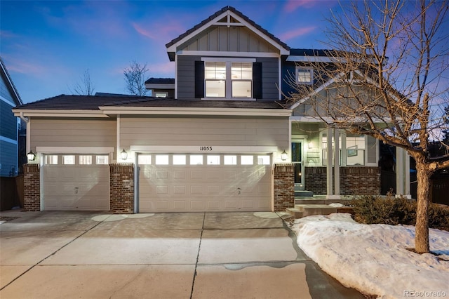 craftsman house featuring driveway, board and batten siding, and brick siding