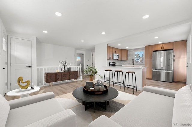 living room with light wood-type flooring and sink