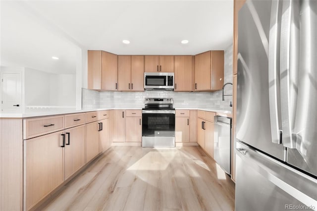 kitchen featuring backsplash, light wood-type flooring, stainless steel appliances, and light brown cabinetry